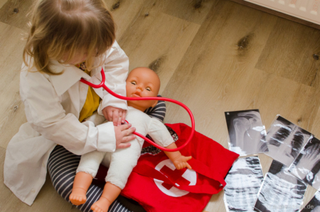 Leni untersucht das Baby. Hörgeräte und Stethoskop sind leider inkompatibel, aber man kann das Ding ja auch um den Hals tragen. Ärztin im Einsatz