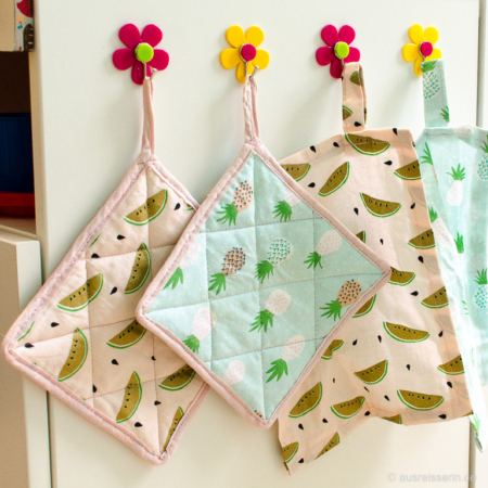 Die Topflappen und Küchentücher habe ich seitlich mit Klebehaken aufgehängt. Griffbereit aufgehängt