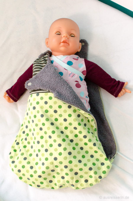 Ab ins Bett: Das Baby bekommt den Schlafsack angezogen. Ab ins Bett