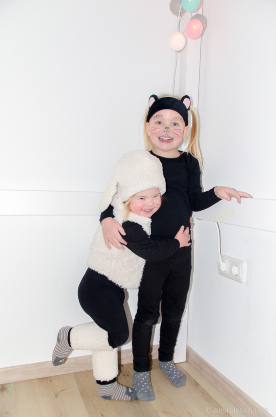 Eine Mütze mit Ohren, Stulpen und die Weste war da: Fertig ist das Schaf! Die Katze geht noch einfacher: Schwarze Klamotten an und das Stirnband (Drogerie) auf die Rübe. Miau! Mäh! Schafkostüm